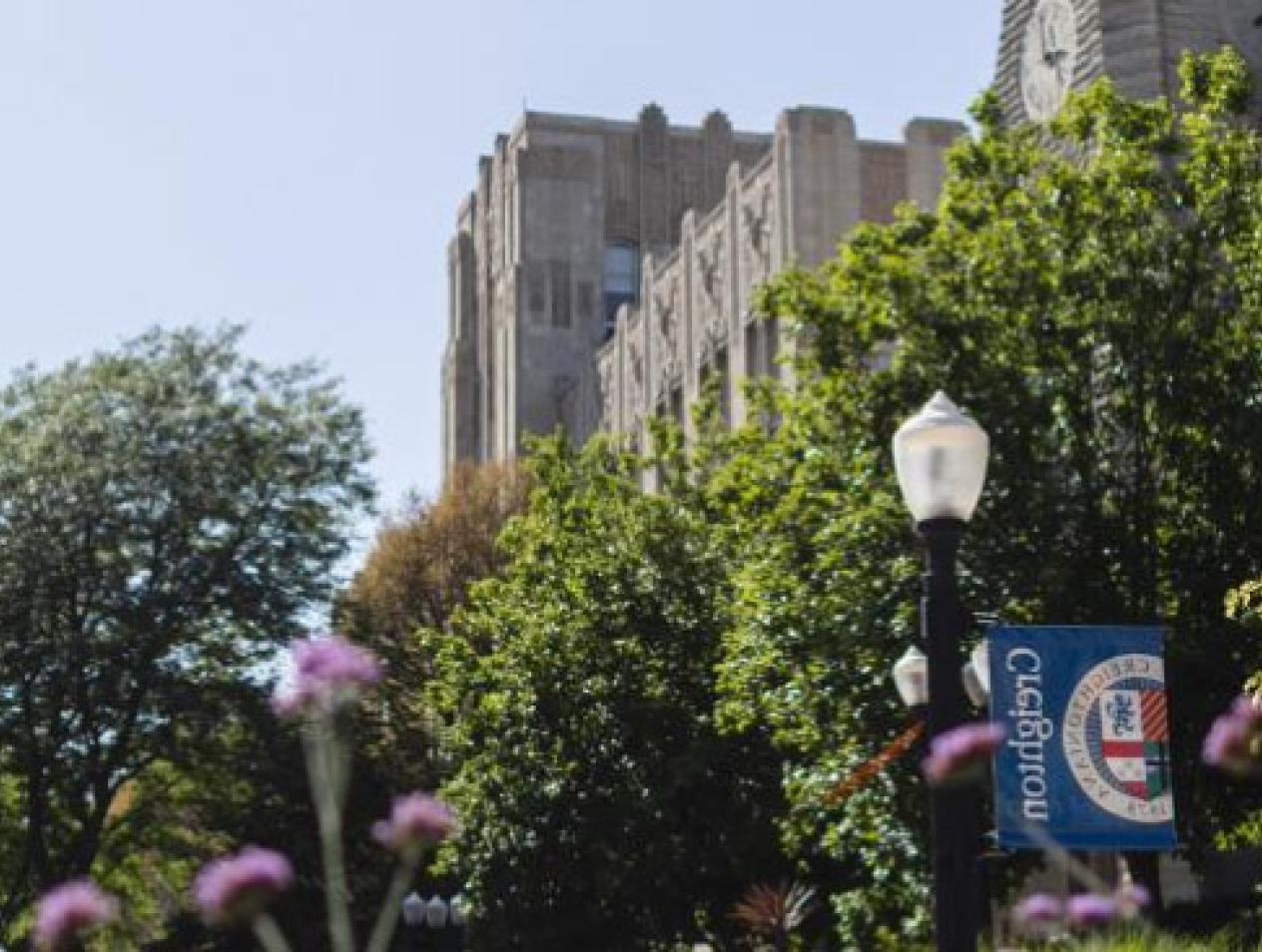 Creighton campus with banner signage and purple flowers