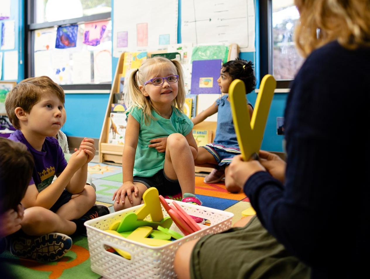 Children learning with teacher in the classroom.